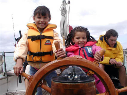 Kamila and Raphaela on the steering wheel of Roselina in New Zealand