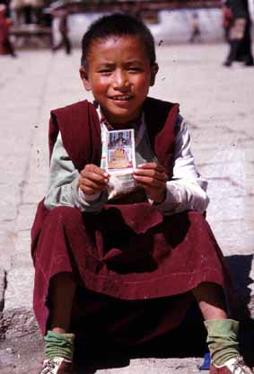 A novice with a picture of Dalai Lama in Lhasa, Tibet